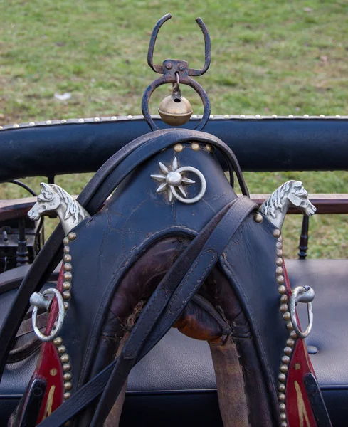 Vintage horse collar decorated with two iron horse heads, rivets and the bell.
