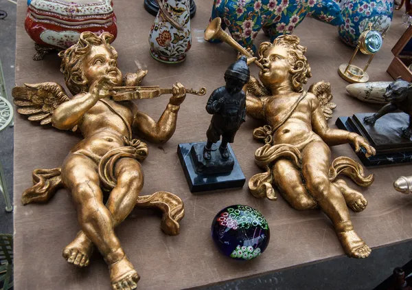 Zwei goldene Engel, die auf Geige und Trompete spielen. Flohmarkt in Paris. — Stockfoto