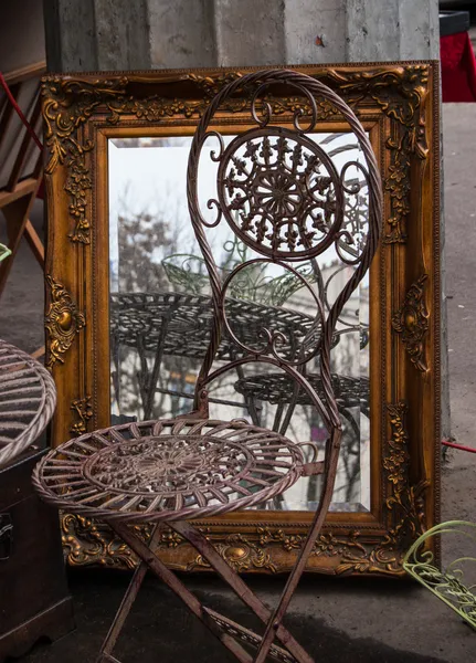 Stühle und Spiegel im goldenen Rahmen auf dem Flohmarkt in Paris. — Stockfoto