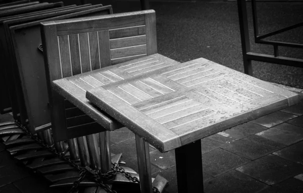 Zebrane i zablokowane café tabel z kroplami deszczu. Czarno-białe. — Zdjęcie stockowe
