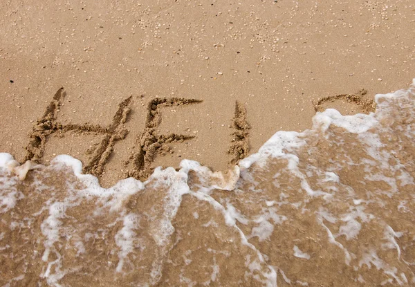 HELP inscription sur la plage de sable baigné par les vagues de la mer . — Photo