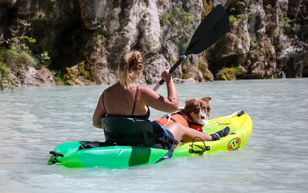 Undefined woman with dog rows in the canoe — Stock Photo, Image