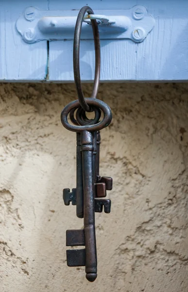 Vintage keys hanging on shutter hanger — Stock Photo, Image