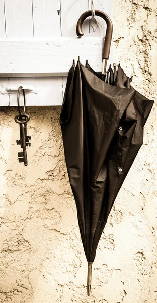 Keys and umbrella hanging on shutter hanger — Stock Photo, Image