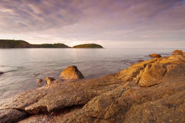 Phuket plaj ön planda ilginç kayalar ile gündoğumu