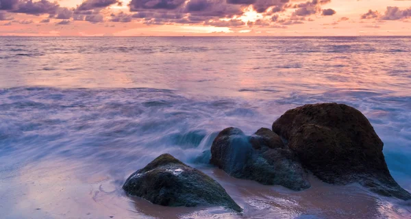 Vague de mer sur le rocher au coucher du soleil — Photo