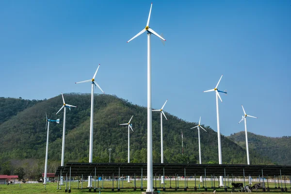 Turbine eoliche che producono energia eolica sotto il cielo blu su un verde — Foto Stock