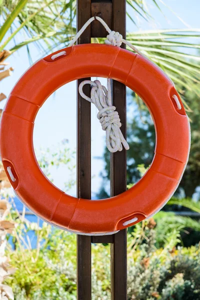 Bóia de vida laranja com corda pendurada ao redor da piscina — Fotografia de Stock