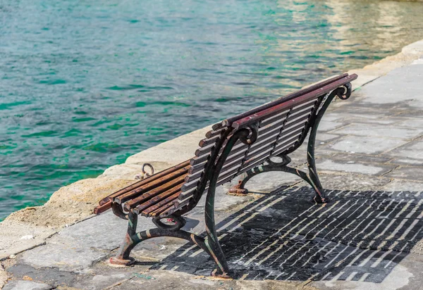 Träbänk på strandpromenaden havet bay — Stockfoto