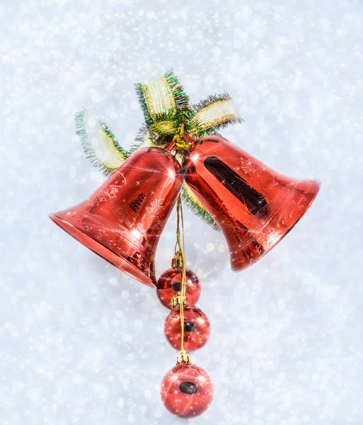 Christmas bells with bow on shiny background snowflakes — Stock Photo, Image