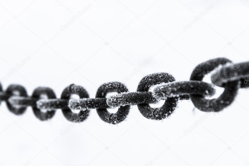 old rusty iron chain on a frost covered with snow