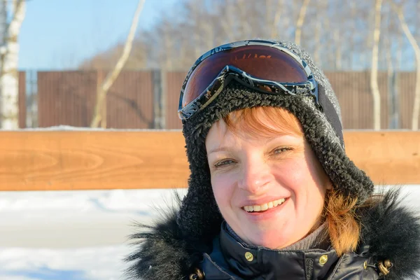 Medelålders brunett på en sluttning i en cap och ski skyddsglasögon — Stockfoto
