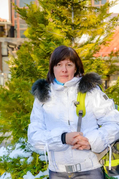 Brünette Frau mittleren Alters in eleganter weißer Jacke mit Fellkapuze — Stockfoto