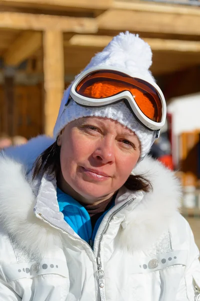 Mujer de mediana edad en una chaqueta blanca y gafas de esquí — Foto de Stock