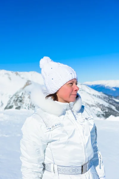 Vrouw in ski pak op een achtergrond van bergen — Stockfoto
