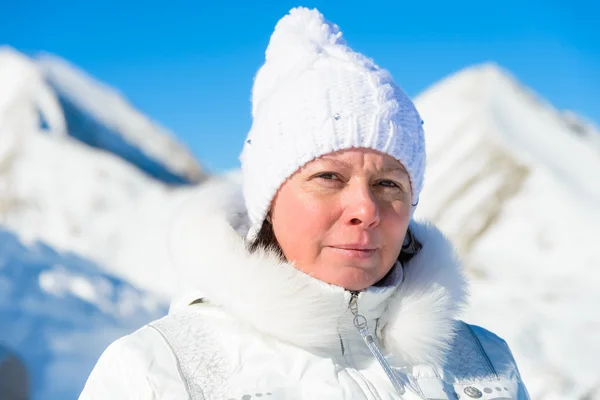 Kvinna i ski passar på en bakgrund av berg — Stockfoto