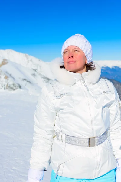 Γυναίκα στο σκι που ταιριάζουν σε ένα φόντο των βουνών — Φωτογραφία Αρχείου