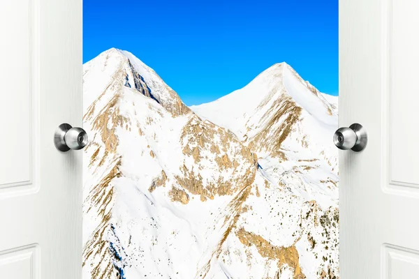 White door open with views of the peaks of snowy mountains — Stock Photo, Image