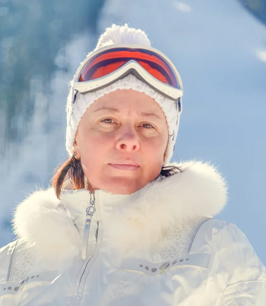 Vrouw van middelbare leeftijd in een witte jas ski bril — Stockfoto