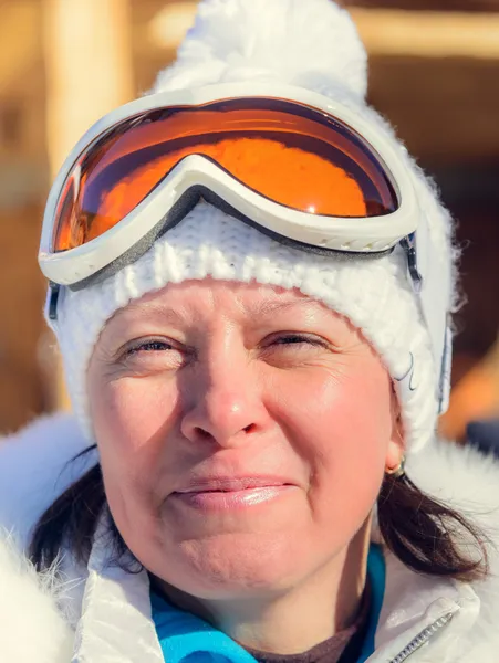 Middle-aged woman in a white jacket  ski  glasses — Stock Photo, Image