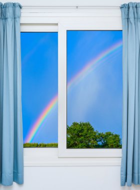 Parlak güneş ışığıyla aydınlatılmış yeşil çayır manzaralı açık bir kapı.