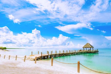 Karayip Denizi 'ndeki bir rıhtımda palmiye yapraklarından bir çatısı olan ahşap bir çardak.