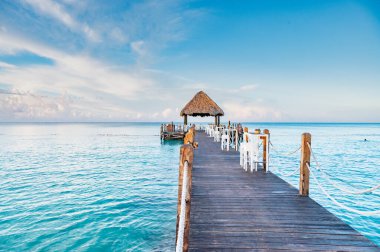 Karayip Denizi 'ndeki bir rıhtımda palmiye yapraklarından bir çatısı olan ahşap bir çardak.