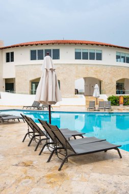 Yüzme havuzunun yanında iki iskemle..