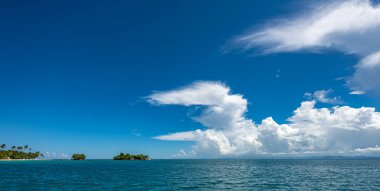 Beyaz kümülüs bulutlar yaz ile açık mavi deniz mavi gökyüzü manzara görünümü
