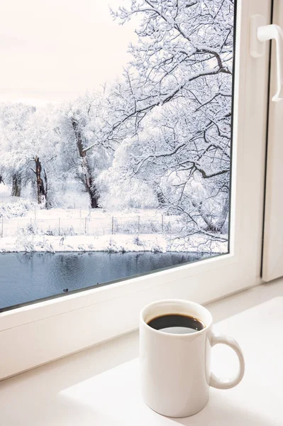 Weiße Kaffeetasse Auf Der Fensterbank Winterlandschaft Vor Dem Fenster lizenzfreie Stockfotos