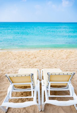 Grup şezlonglar kumsal deniz üzerinde bir şemsiye altında