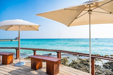 Dominik Cumhuriyeti adasının kıyısında sazdan şemsiyeli kumsal