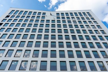 Birçok küçük penceresi olan bir binanın ön cephesine bakıyorum. Binaya bak.