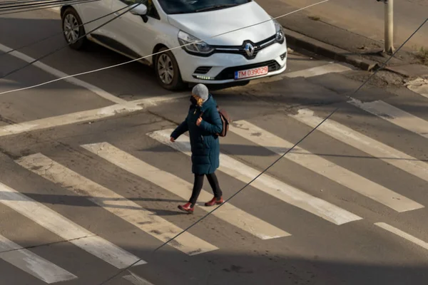 Timisoara, Romanya - 20 Aralık 2021: Karşıdan karşıya geçen kadın. Gerçek insanlar..