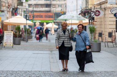 Timisoara, Romanya - 03 Mayıs 2016: Elinde şemsiyeyle sokakta yürüyen kadın. Gerçek insanlar..