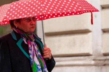 Timisoara, Romanya - 03 Mayıs 2016: Elinde şemsiyeyle sokakta yürüyen kadın. Gerçek insanlar..