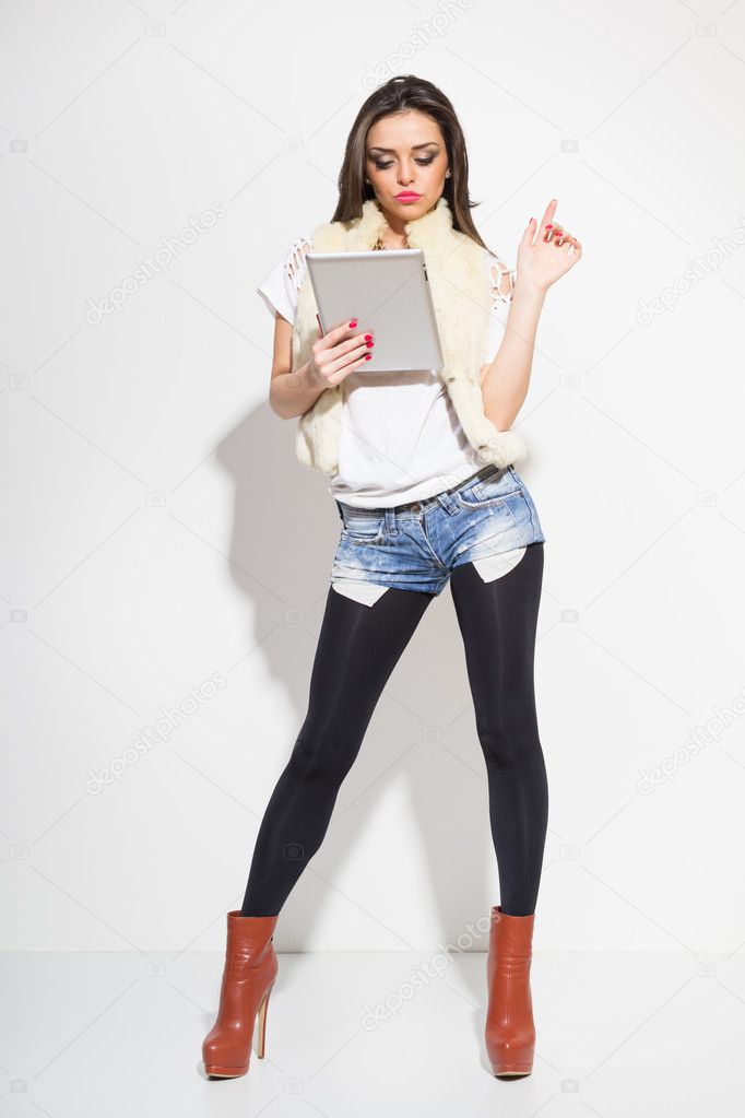 Sexy fashionable young woman using digital tablet