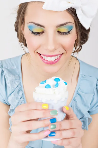 Симпатичная девушка с красочным макияжем и маникюром держит мороженое — стоковое фото
