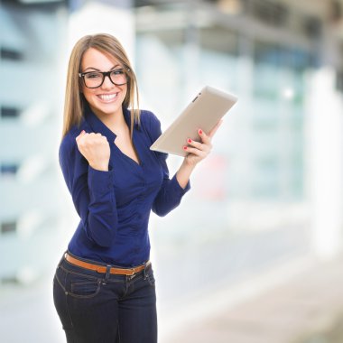Happy young businesswoman with tablet computer