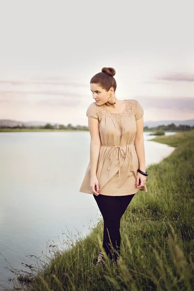 Young brunette enjoying walk by the lake — Stock Photo, Image