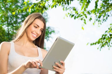 Genç öğrenci kız açık havada Tablet PC'yi kullanma