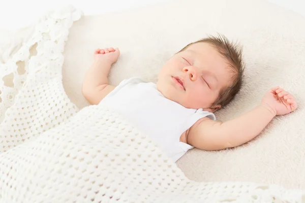 Расслабленный ребенок спит в трикотажном белом одеяле — стоковое фото