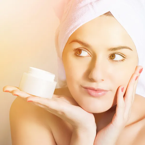 Mujer cuidando su piel aplicando crema facial — Foto de Stock