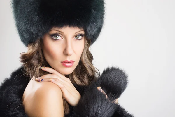 Glamorous young woman wearing black fur — Stock Photo, Image