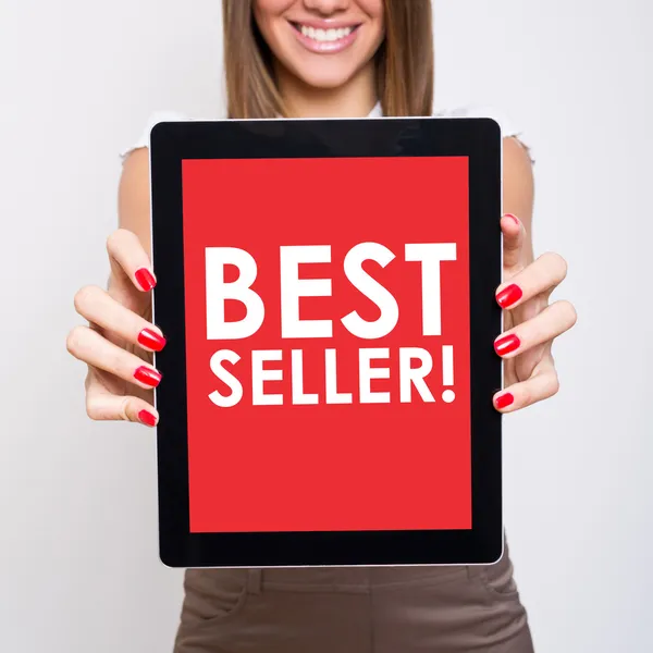 Donna che mostra tablet computer che afferma best seller — Foto Stock