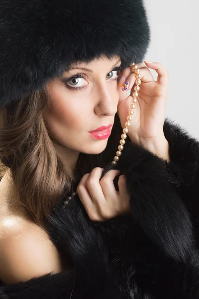 Sinnliche Frau mit schwarzem Pelz und Perlen — Stockfoto