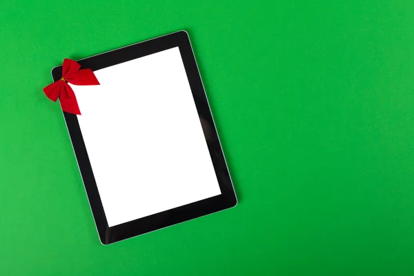 緑色の背景で弓でタブレット コンピューター — ストック写真
