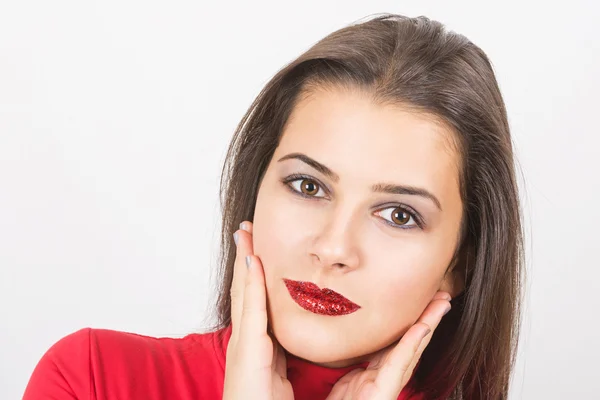 Mooie jonge vrouw met rode pailletten op haar lippen — Stockfoto