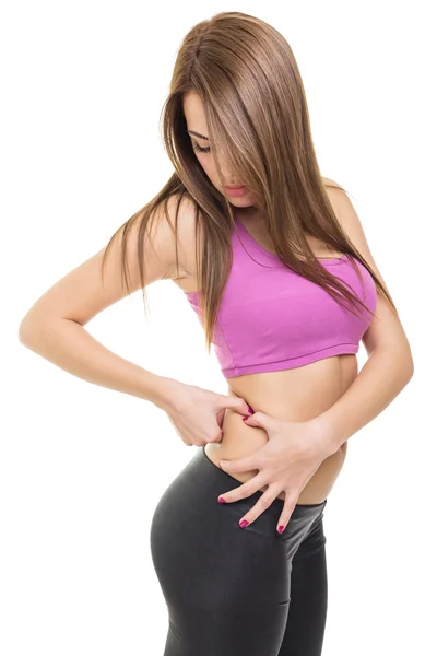 Fit beautiful young woman pinching fat on her waist — Stock Photo, Image