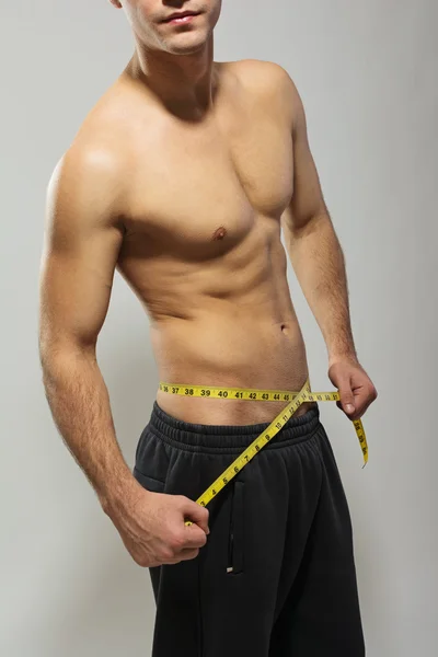 Shirtless fit jonge man meten zijn taille — Stockfoto